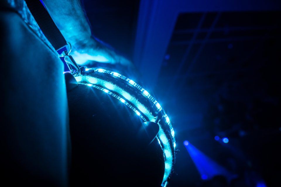 Close-up of a blue-lit LED djembe during a live percussion set in a dark club