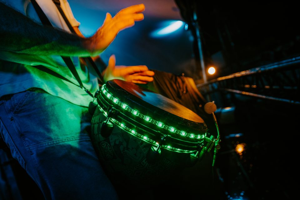 Live djembe with green LED lighting during a dance festival performance