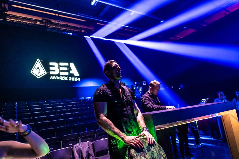 Sam Anderson playing the LED djembe on stage at an awards gala