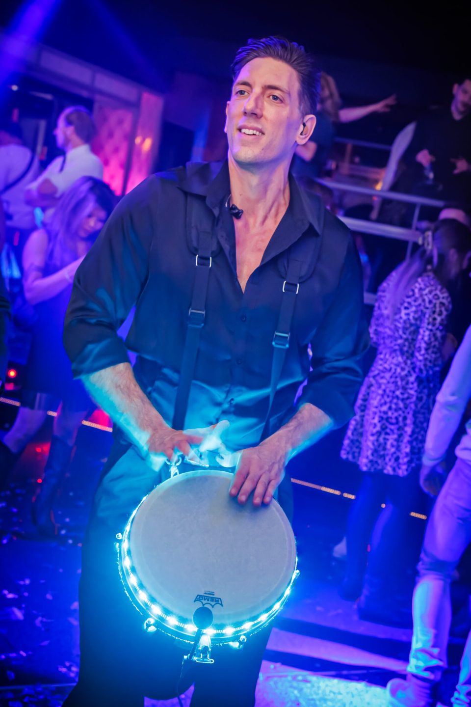 Sam Anderson playing a glowing blue LED djembe in a club