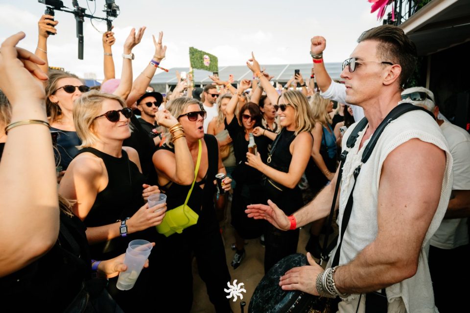 Live djembe in the middle of an ecstatic festival crowd with hands in the air