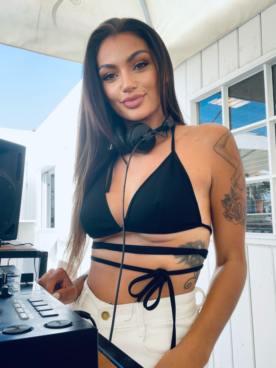 DJ Vilalica with headphones at the decks on a sunny terrace