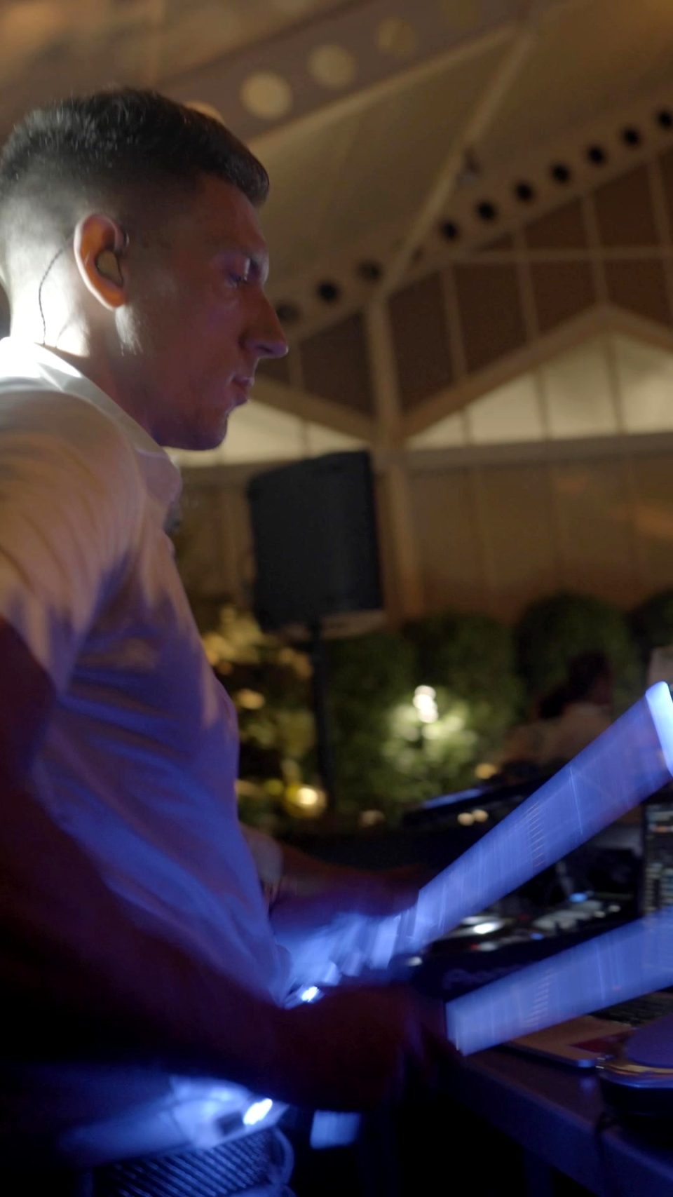 Sam Anderson playing glowing sticks next to the DJ booth at a wedding