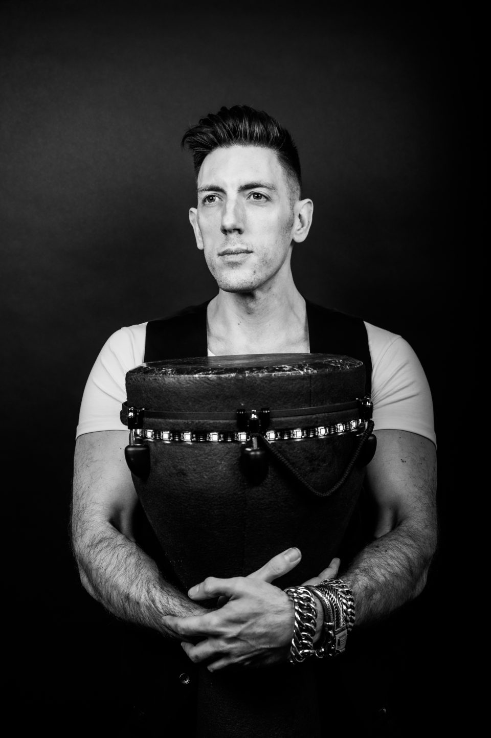 Black-and-white portrait of a percussionist holding his djembe